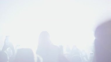 Arkadan, bir hayran kitlesi canlı müzik konserinin tadını çıkarıyor. Çoğu kişi diziyi kaydetmek için akıllı telefonları soyuyor. Parlak sahne ışıkları altında dans eden bir kadın..