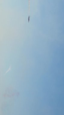 Açık mavi gökyüzüne doğru uçan akrobatik bir dublörün dikey görüntüsü uzun ve kalın bir duman izi bırakıyor. Geniş kopya alanına sahip Airshow performans kavramı.