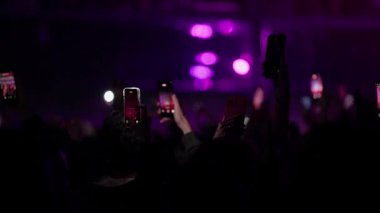 Canlı konserdeki seyircilerin akıllı telefonlarıyla sahneyi çektikleri bir video sahnesi. Işıklar parlak pembe ve kırmızıdan koyu renge, sonra da parlak mor ve pembe renge dönüşür..