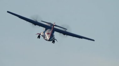 MADRID, SPAIN - 12 Ekim 2025: çift motorlu bir turboprop askeri veya sahil güvenlik uçağının uçuşu görüntüleri. İniş takımlarını indiren uçak, açık mavi gökyüzüne karşı sola bir bankacılık dönüşü gerçekleştiriyor..