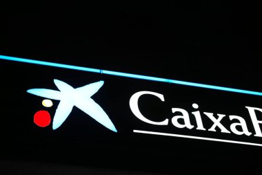 VALENCIA, SPAIN - 6 Şubat 2026: Gece vakti öne çıkan İspanyol bankacılık grubu CaixaBank 'ın mavi yıldız logosuna ve beyaz tipografisine yakından bakın