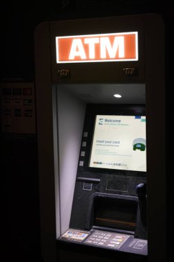 VALENCIA, İSPA - 6 Şubat 2026: EuroNet otomatik veznedar makinesinin aydınlatılmış ekran hoş geldin mesajı ve geceleri kredi kartı takmak için talimatlar