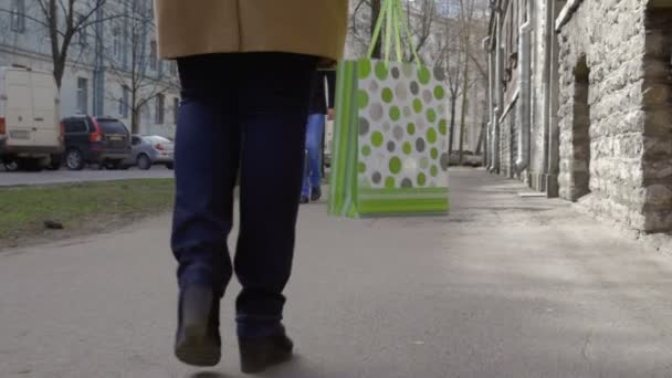 Mujer caminando por la ciudad y llevando bolsa de compras — Vídeos de Stock