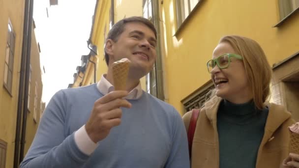 Feliz hombre y mujer comiendo helado durante un paseo — Vídeos de Stock