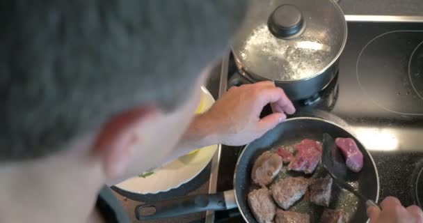 Мужчина готовит вкусный ужин дома — стоковое видео