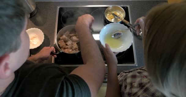 Pareja cocinando juntos carne y salsa — Vídeos de Stock