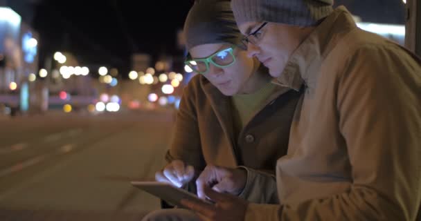 Mann und Frau mit Tablet-PC an Straßenbahnhaltestelle — Stockvideo