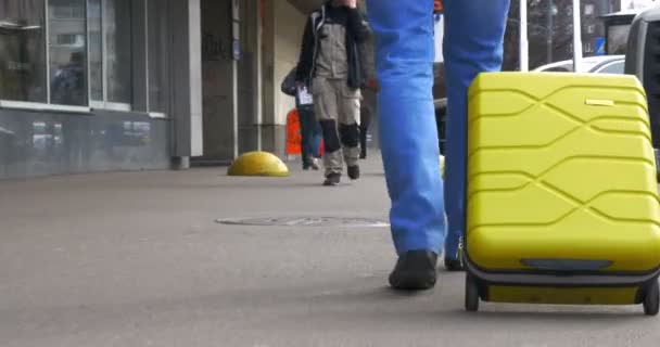 Человек с чемоданом на колёсах на городской улице — стоковое видео