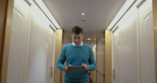 Człowiek pracujący z podkładem w hotelowym korytarzu — Wideo stockowe