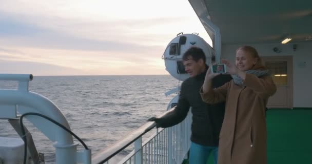 Молодая пара делает селфи по телефону на борту судна — стоковое видео