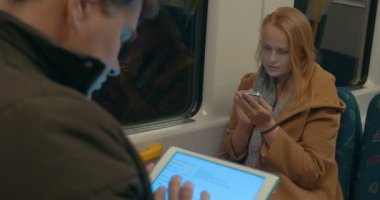 Woman Typing in Smartphone while Riding the Subway