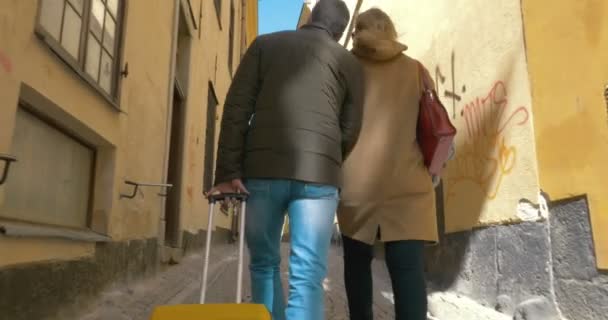 Eski sokakta yürüyen rulo çanta ile turist çift — Stok video