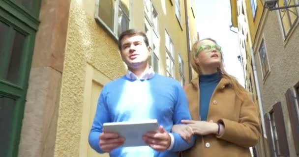 Par turister med Tablet PC vandra i gamla stan — Stockvideo