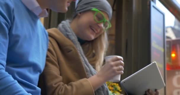 Sonriente pareja de adultos sentados en el café de la calle — Vídeos de Stock