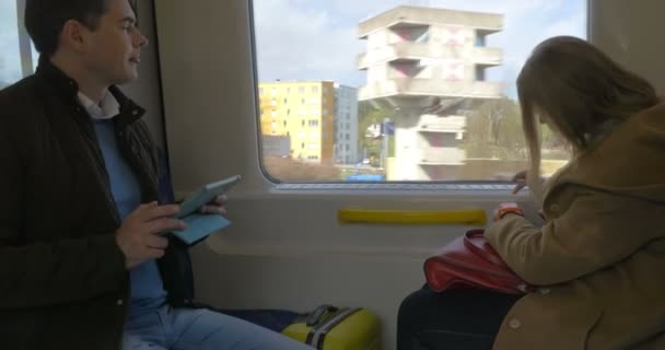 Два пассажира в поезде с помощью планшета и умных часов — стоковое видео