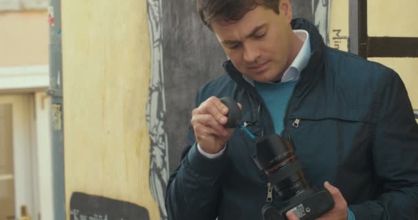 清洁相机与镜头鼓风机的摄影师 — 图库视频影像