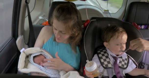 कार में यात्रा करने वाले दो बच्चों वाली महिला — स्टॉक वीडियो