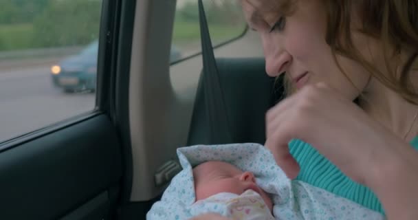 Mulher com bebê nos braços montando um carro — Vídeo de Stock