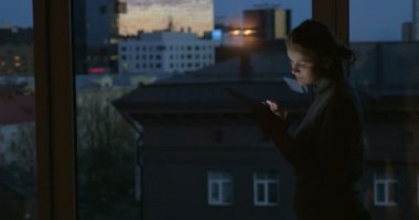 Gece pencerenin yanında pedle çalışan kız
