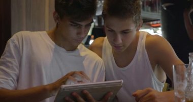 İki genç kullanarak tablet Pc kafede