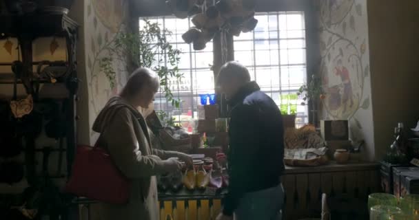 Pareja joven mirando los zapatos en una pequeña tienda — Vídeos de Stock