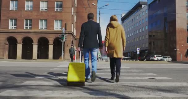 Hombre y mujer con maleta cruzando la calle — Vídeos de Stock