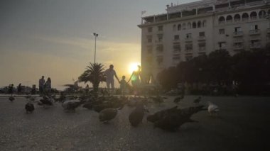 Sokakta üç kişilik aile ve güvercinler
