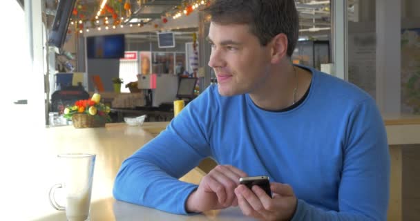 Hombre sentado en la cafetería con Smartphone — Vídeos de Stock