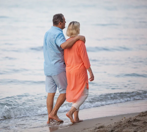 Couple aîné profitant d'une promenade pieds nus au bord de la mer — Photo