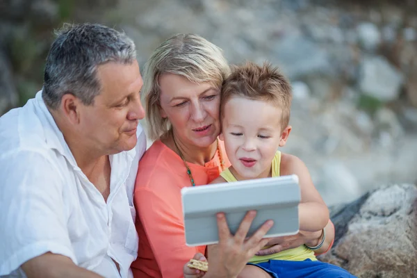 Abuelos y nieto con tableta PC al aire libre — Foto de Stock