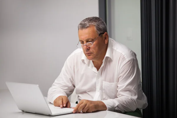 Homme d'affaires senior travaillant avec un ordinateur portable au bureau — Photo