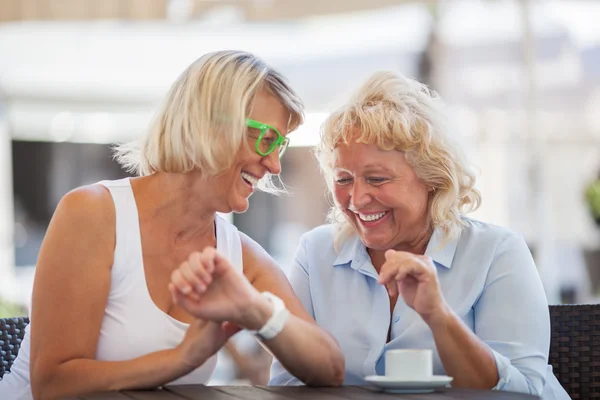 Senior women laughing in street cafe — Zdjęcie stockowe