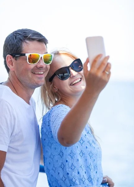 Cheerful couple in sunglasses taking mobile selfie — Stock fotografie