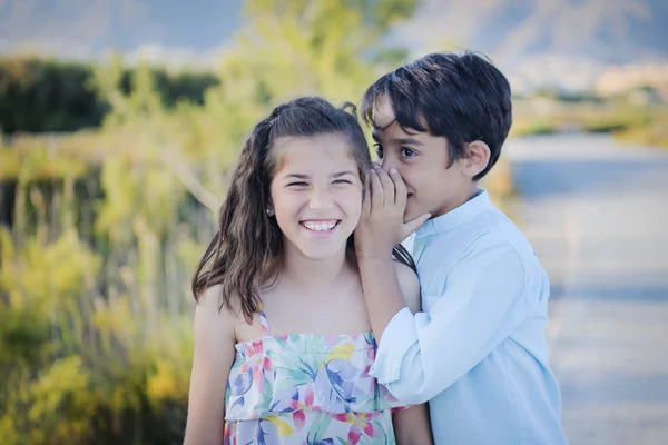 Menino e menina sussurrando — Fotografia de Stock