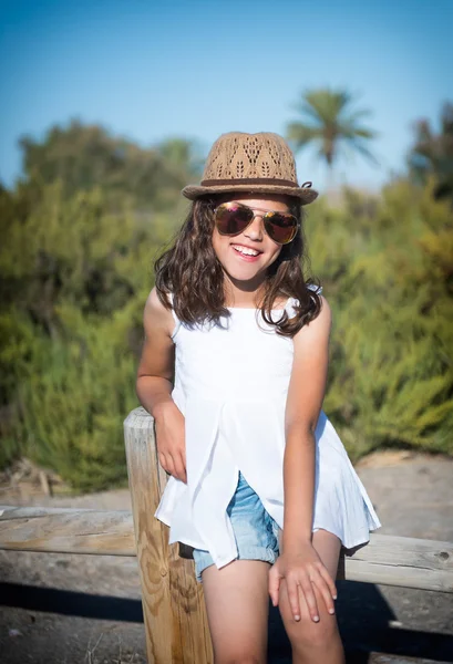Chica joven en gafas de sol sobre un fondo de la naturaleza — Foto de Stock
