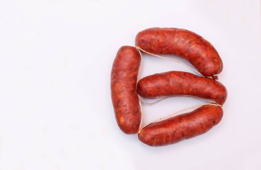 Taze sosisler, temiz beyaz arka planda güzelce yerleştirilmiş.