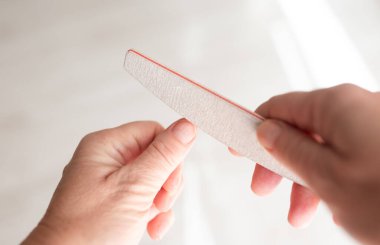 Tırnaklarını törpüleyen kadın, parlak sabah ışığı, güzellik salonu servisi, hijyen ürünleri markaları..