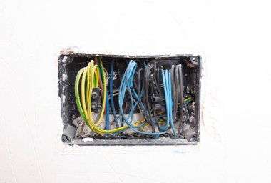 Profesyonel elektrik kablosu kurulumu, kabataslak bitiş aşamasında siyah soket kutusundaki renkli kablolar ve terminal blokları kullanarak.