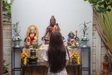 Arka tarafı yakın, uzun saçlı Asyalı Lord Shiva 'nın heykelinden bir dilek diliyor..