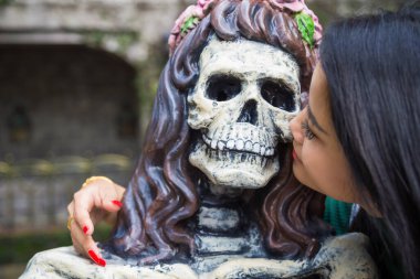 Asyalı bir kadının yanağından öptüğü iskelet parmak izini kapat..