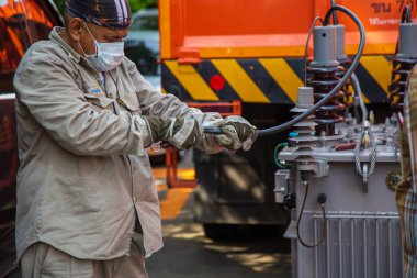 Nonthaburi, Tayland - 19 Mayıs 2021 Elektrik telleri elektrik direğine trafo yerleştirmeden önce kabloları söküyor