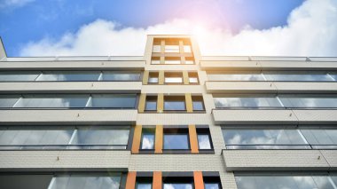 Modern ve yeni apartman. Çok katlı modern, yeni ve şık apartman daireleri. Parlak güneşli bir günde masmavi gökyüzünde güneş ışığıyla yüzler.