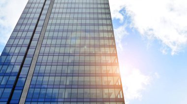 İş bölgesindeki modern ofis binalarının alt manzarası. Gökdelen cam cepheleri masmavi gökyüzünde güneş ışınlarıyla aydınlık bir günde.