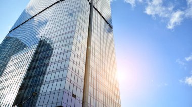 İş bölgesindeki modern ofis binalarının alt manzarası. Gökdelen cam cepheleri masmavi gökyüzünde güneş ışınlarıyla aydınlık bir günde.