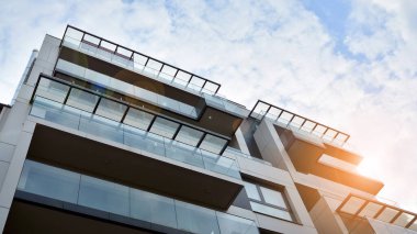 Modern ve yeni apartman. Çok katlı modern, yeni ve şık apartman daireleri. Parlak güneşli bir günde masmavi gökyüzünde güneş ışığıyla yüzler.