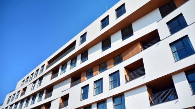 Modern ve yeni apartman. Çok katlı modern, yeni ve şık apartman daireleri. Parlak güneşli bir günde masmavi gökyüzünde güneş ışığıyla yüzler.