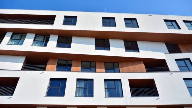Modern ve yeni apartman. Çok katlı modern, yeni ve şık apartman daireleri. Parlak güneşli bir günde masmavi gökyüzünde güneş ışığıyla yüzler.