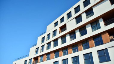 Modern ve yeni apartman. Çok katlı modern, yeni ve şık apartman daireleri. Parlak güneşli bir günde masmavi gökyüzünde güneş ışığıyla yüzler.