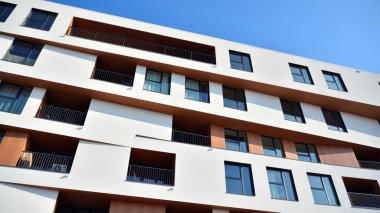 Modern ve yeni apartman. Çok katlı modern, yeni ve şık apartman daireleri. Parlak güneşli bir günde masmavi gökyüzünde güneş ışığıyla yüzler.