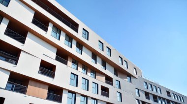 Modern ve yeni apartman. Çok katlı modern, yeni ve şık apartman daireleri. Parlak güneşli bir günde masmavi gökyüzünde güneş ışığıyla yüzler.